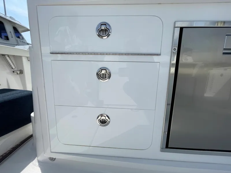 Slide: The Image of 2022 Bertram 39 CC boat interior with sleek white storage drawers and stainless steel accents. - 32