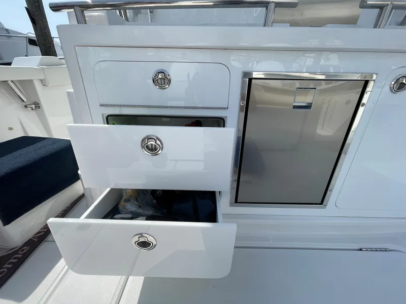 Slide: The Image of 2022 Bertram 39 CC boat interior with open storage drawers and stainless steel cabinet. - 33