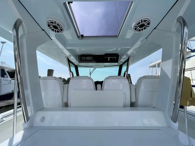 Slide: The Image of 2022 Bertram 39 CC boat interior with skylight and white seating. - 34