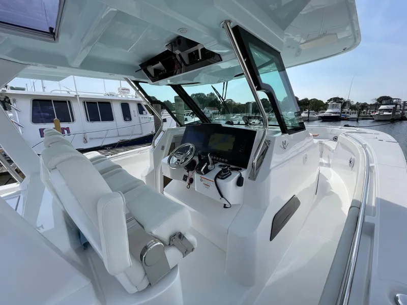 Slide: The Image of 2022 Bertram 39 CC boat interior with modern helm and seating at marina. - 36