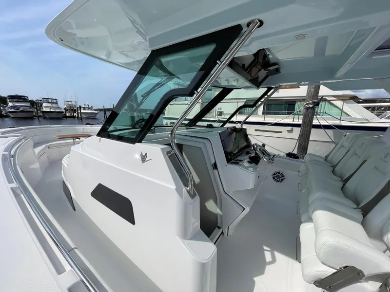 Slide: The Image of 2022 Bertram 39 CC boat interior with sleek design and modern controls at a marina. - 37
