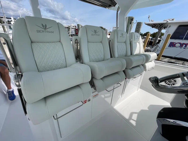 Slide: The Image of Luxury seating on a 2022 Bertram 39 CC boat, featuring plush, embroidered chairs. - 39