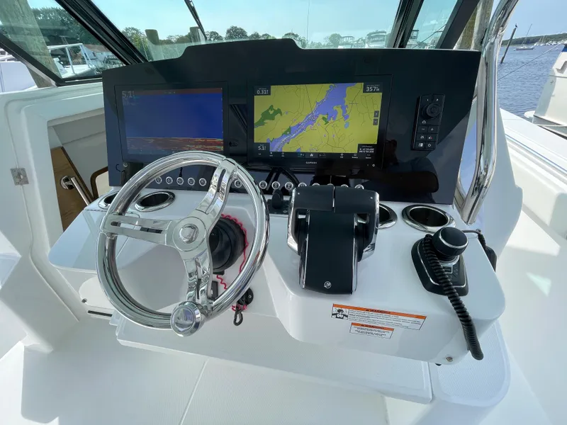 Slide: The Image of 2022 Bertram 39 CC helm with navigation screens and steering wheel, showcasing modern marine technology. - 40