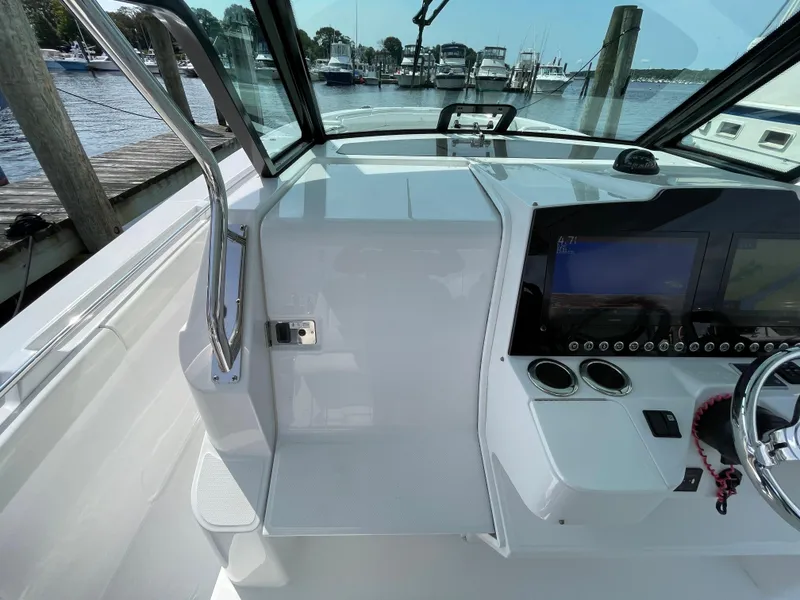 Slide: The Image of Cockpit view of 2022 Bertram 39 CC boat with modern dashboard and marina background. - 47