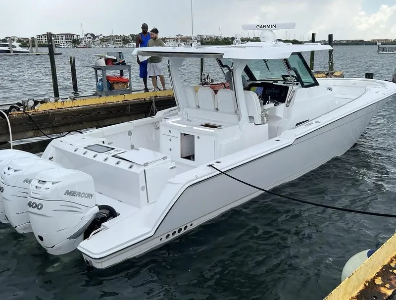 Slide: The Image of 2022 Bertram 39 CC boat docked, featuring dual Mercury 400 engines, sleek white design. - 5