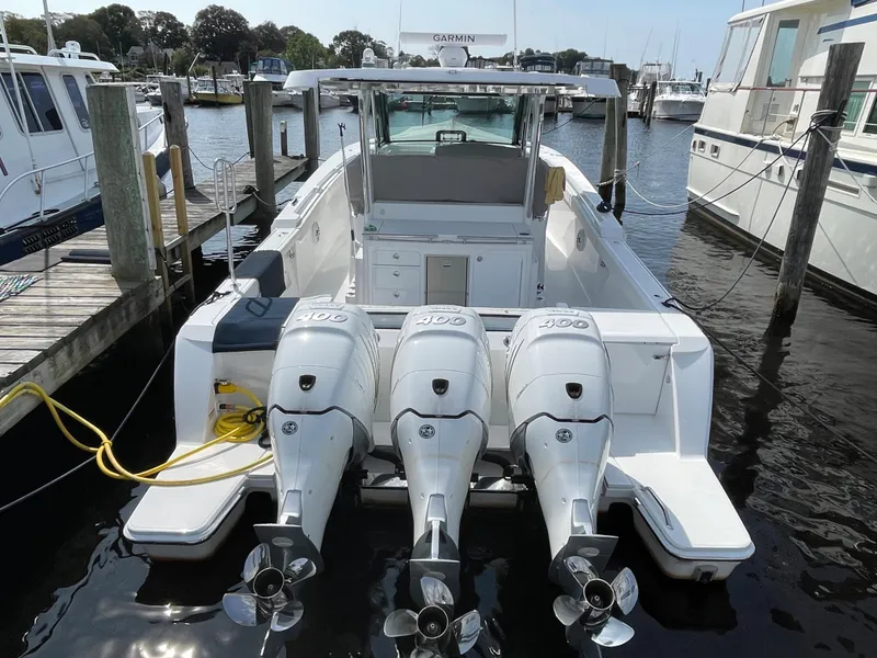 Slide: The Image of 2022 Bertram 39 CC boat with triple outboard engines docked at marina. - 6