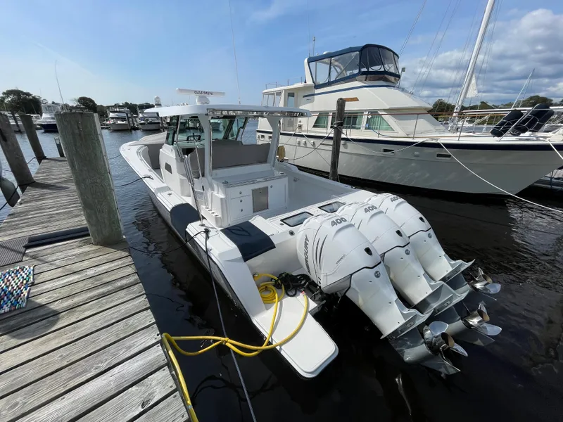 Slide: The Image of 2022 Bertram 39 CC boat docked, featuring triple outboard engines. - 7