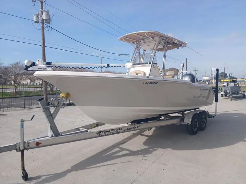 Slide: The Image of 2020 Key West 239 boat on trailer, parked outdoors under clear sky. - 10