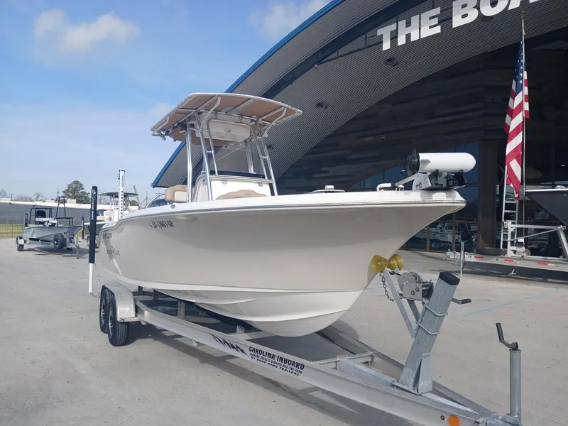 Slide: The Image of 2020 Key West 239 boat on trailer, parked outside a large building with an American flag. - 9