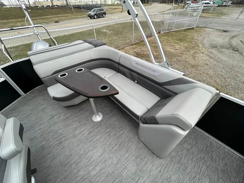 Slide: The Image of 2021 Bennington 21SLX pontoon boat interior with gray seating and table. - 10