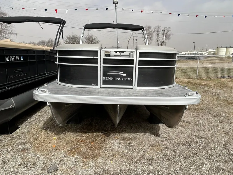 Slide: The Image of 2021 Bennington 21SLX pontoon boat on display in a gravel lot. - 5