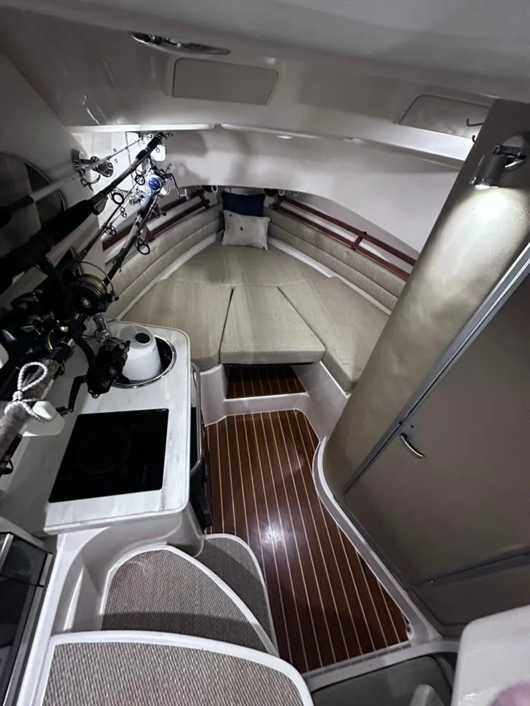 Slide: The Image of 2018 Grady-White Marlin 300 cabin interior with kitchenette and seating area. - 12
