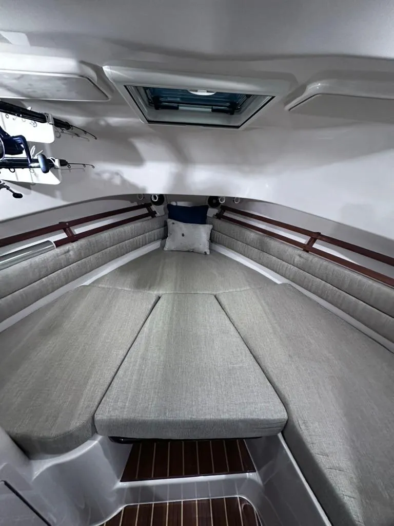 Slide: The Image of 2018 Grady-White Marlin 300 cabin interior with cushioned seating and wood flooring. - 13
