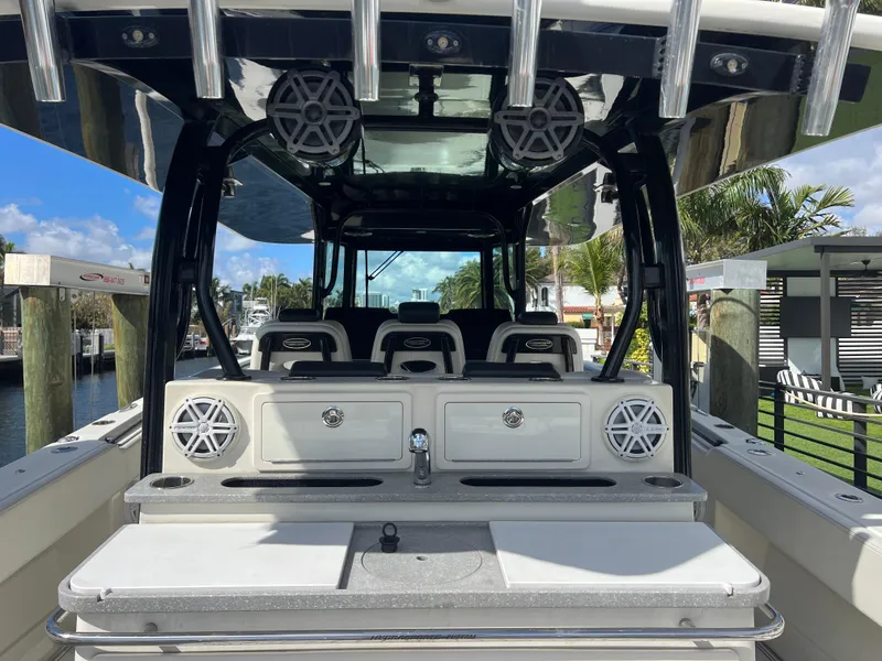 Slide: The Image of 2017 Hydra-Sports 4200 Siesta boat interior with seating and speakers, docked by a canal. - 11