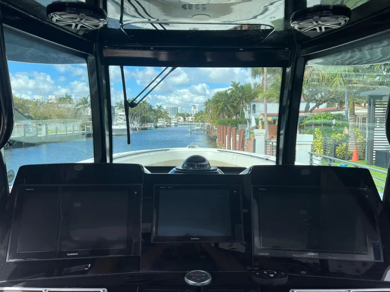 Slide: The Image of 2017 Hydra-Sports 4200 Siesta boat cockpit with navigation screens, overlooking a scenic waterway. - 28