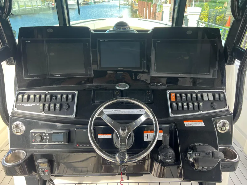 Slide: The Image of Control panel of a 2017 Hydra-Sports 4200 Siesta boat with multiple screens and steering wheel. - 6