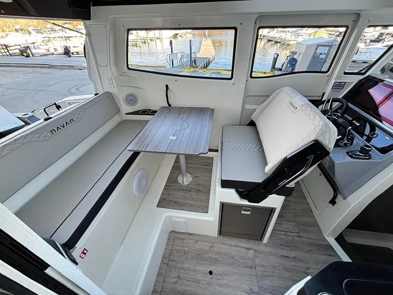 Slide: The Image of Interior of 2025 Navan C30 boat with seating, table, and helm, dockside view. - 14