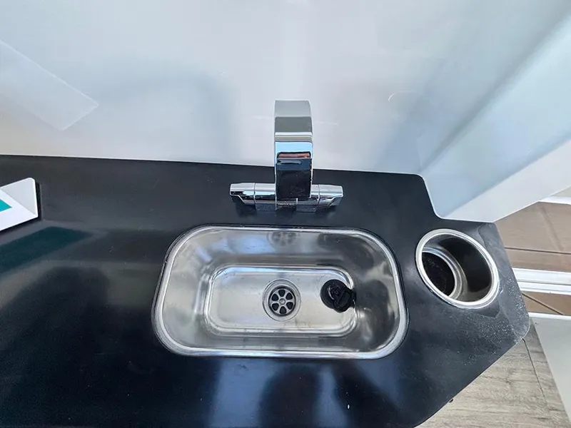 Slide: The Image of Compact sink and faucet in Navan C30, 2025 model, with sleek black countertop design. - 29