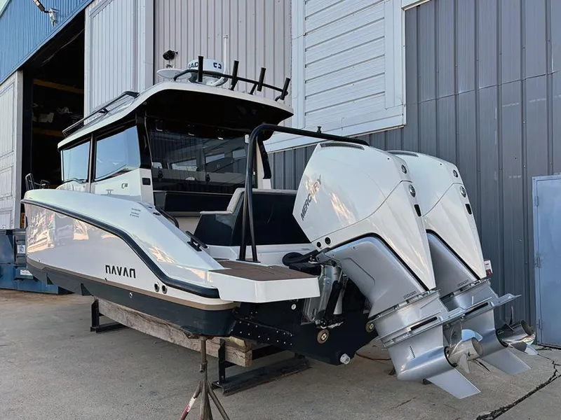 Slide: The Image of Navan C30 2025 boat with dual outboard motors, docked near industrial building. - 3