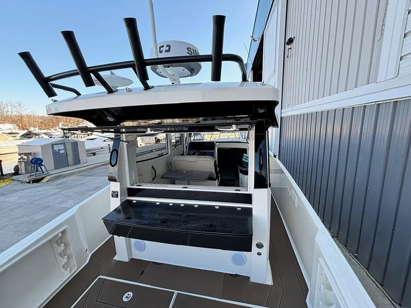 Slide: The Image of 2025 Navan C30 boat with fishing rod holders and spacious deck, docked near a building. - 8
