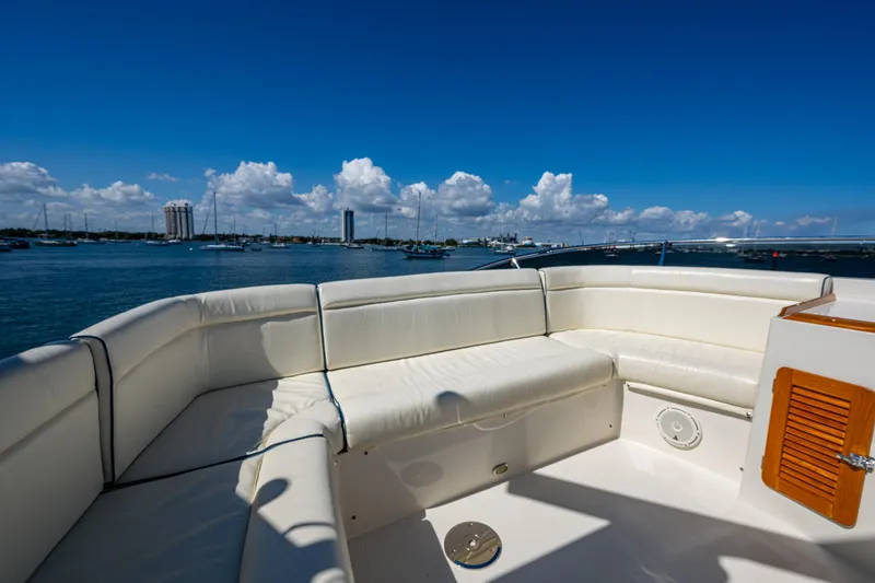 Slide: The Image of Hinckley Talaria 43 Flybridge 2019 yacht with white seating, overlooking a scenic waterfront. - 12