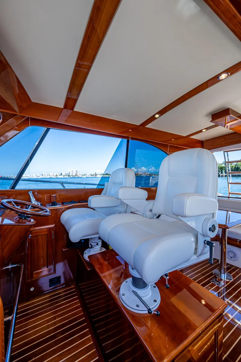Slide: The Image of Luxurious 2019 Hinckley Talaria 43 Flybridge interior with plush white seating and wooden accents. - 23