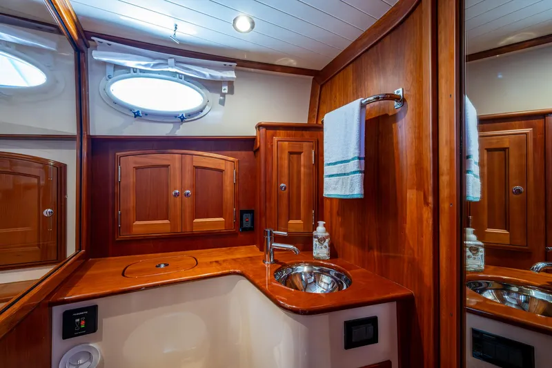 Slide: The Image of Luxurious 2019 Hinckley Talaria 43 Flybridge bathroom with wood cabinetry and stainless steel sink. - 30