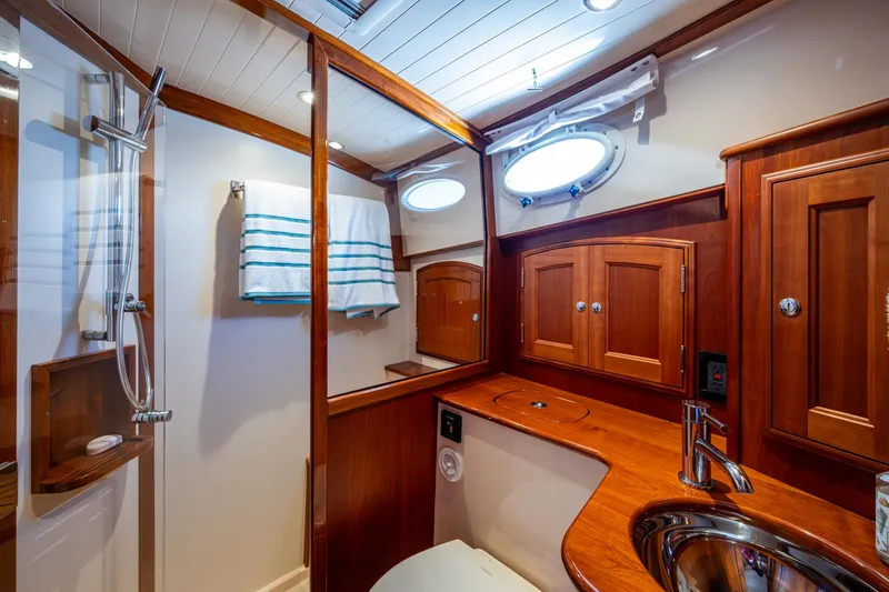 Slide: The Image of Luxurious 2019 Hinckley Talaria 43 Flybridge bathroom with wood cabinetry and modern fixtures. - 31