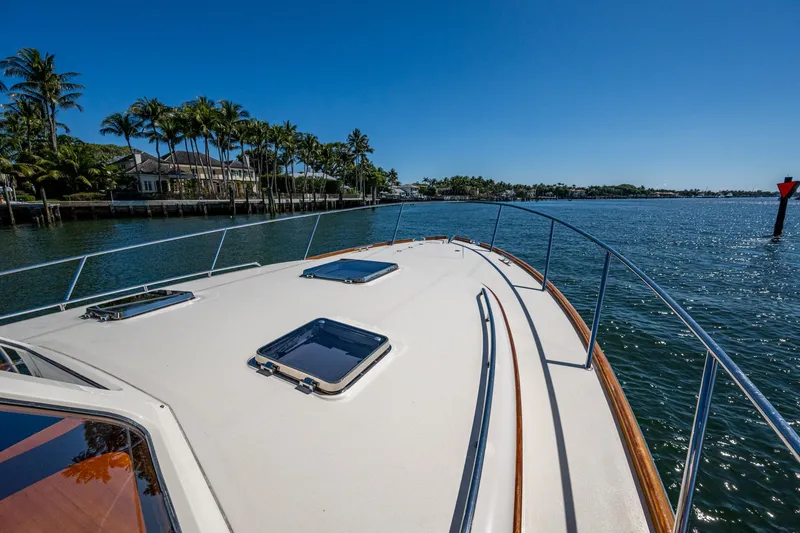 Slide: The Image of 2019 Hinckley Talaria 43 Flybridge cruising on a sunny day near palm-lined shore. - 36