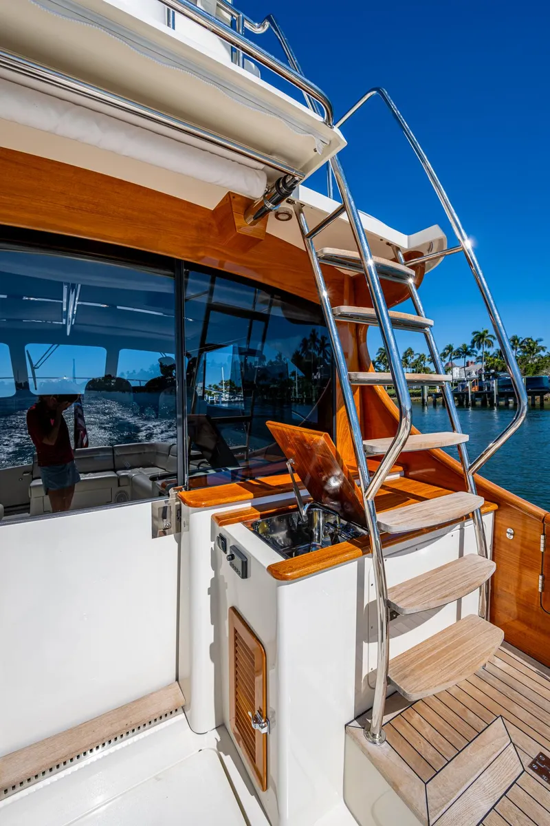 Slide: The Image of 2019 Hinckley Talaria 43 Flybridge yacht with wooden accents and stainless steel ladder. - 9