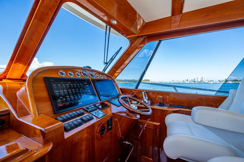 Slide: The Image of 2019 Hinckley Talaria 43 Flybridge helm with polished wood and modern navigation equipment. - 24