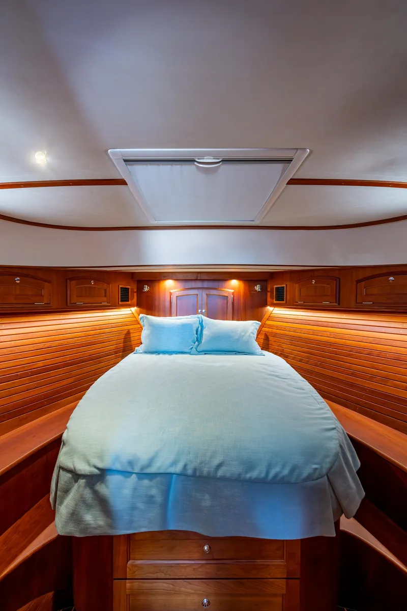 Slide: The Image of 2019 Hinckley Talaria 43 Flybridge cabin with cozy bed and elegant wood paneling. - 29