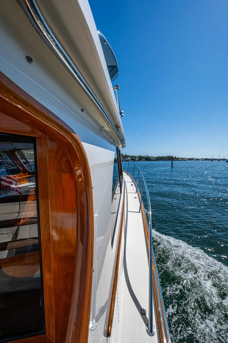 Slide: The Image of 2019 Hinckley Talaria 43 Flybridge cruising on a sunny day, side view. - 35