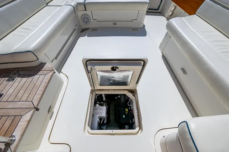 Slide: The Image of 2019 Hinckley Talaria 43 Flybridge engine compartment, surrounded by white seating and teak flooring. - 39