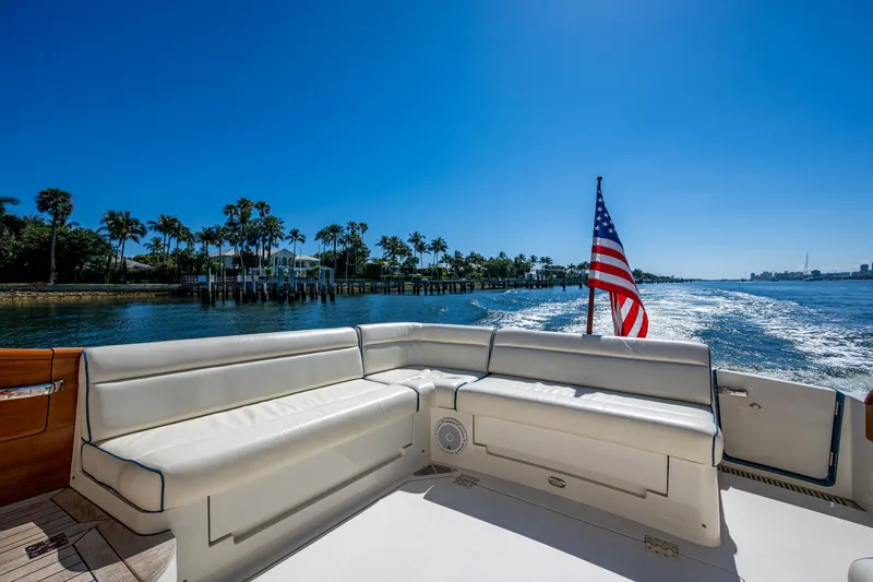 Slide: The Image of Hinckley Talaria 43 Flybridge 2019 yacht with American flag, cruising on a sunny day. - 7