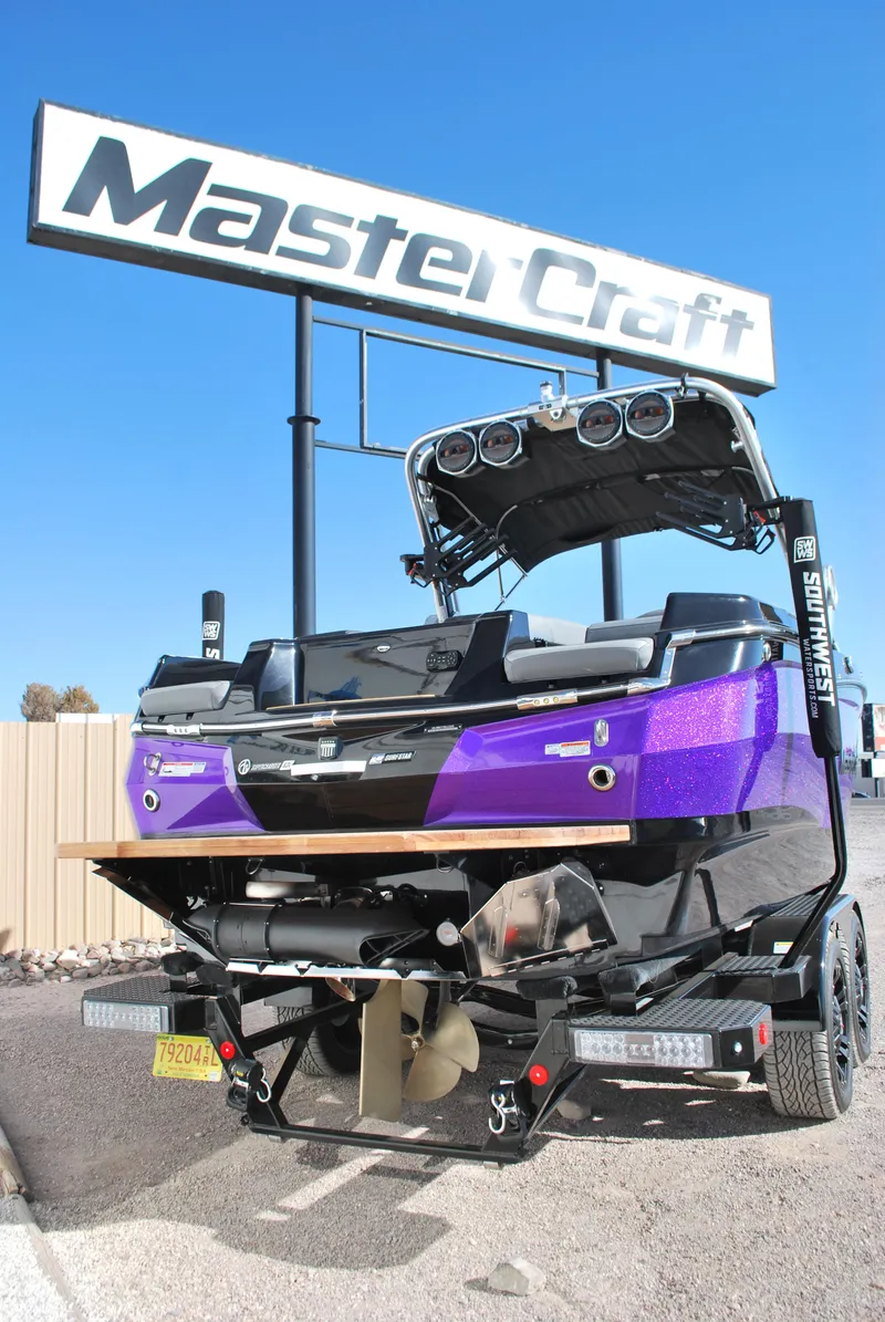 Slide: The Image of 2023 MasterCraft XStar S boat in vibrant purple, displayed outdoors under a MasterCraft sign. - 19