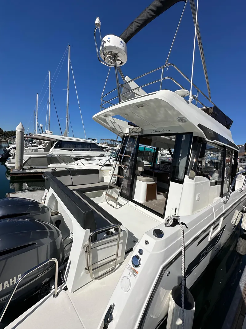 Slide: The Image of 2021 Jeanneau NC 1095 Fly yacht docked at marina, featuring sleek design and modern amenities. - 10