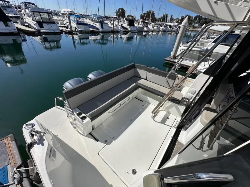 Slide: The Image of 2021 Jeanneau NC 1095 Fly at marina, featuring spacious deck and seating area. - 11