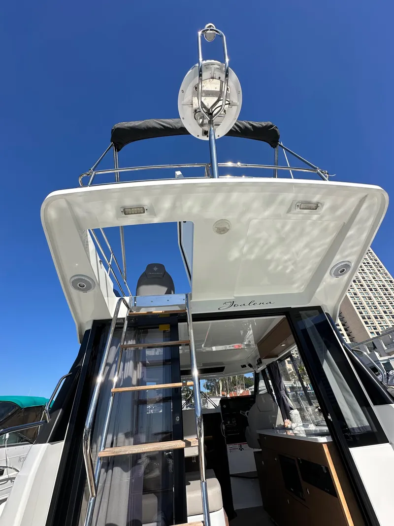 Slide: The Image of 2021 Jeanneau NC 1095 Fly yacht, exterior view with flybridge and clear blue sky. - 13