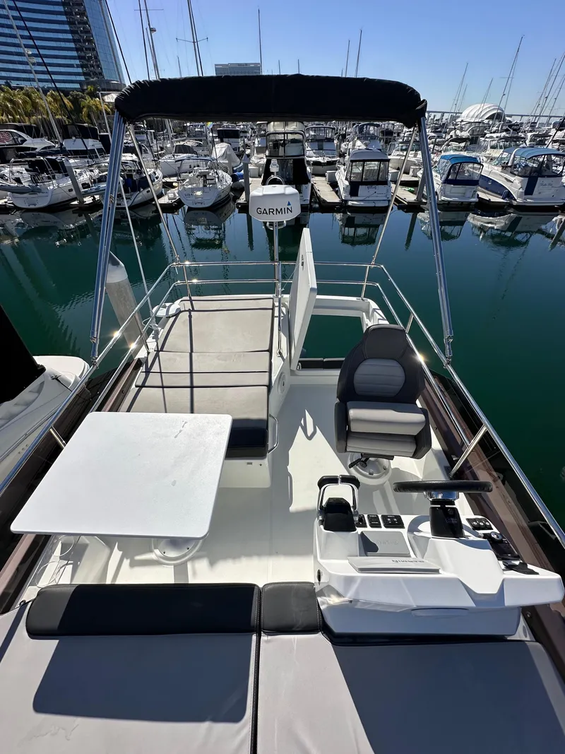 Slide: The Image of 2021 Jeanneau NC 1095 Fly at marina, featuring spacious flybridge and seating area. - 19