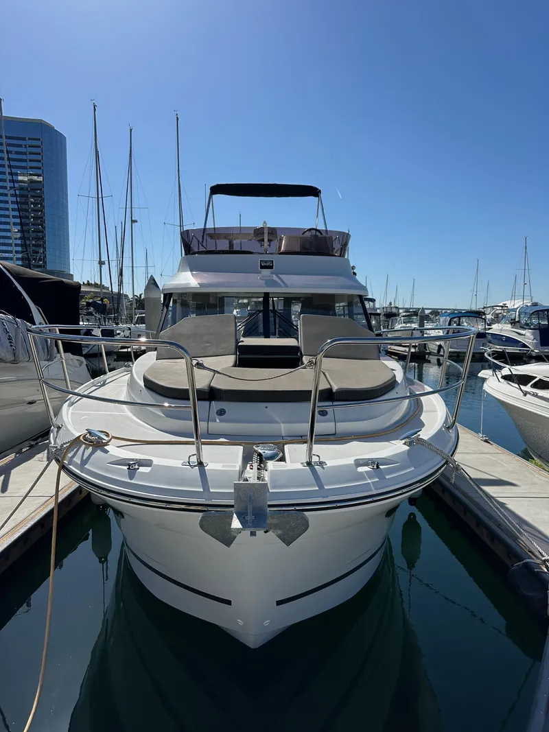 Slide: The Image of 2021 Jeanneau NC 1095 Fly yacht docked in marina, front view. - 2