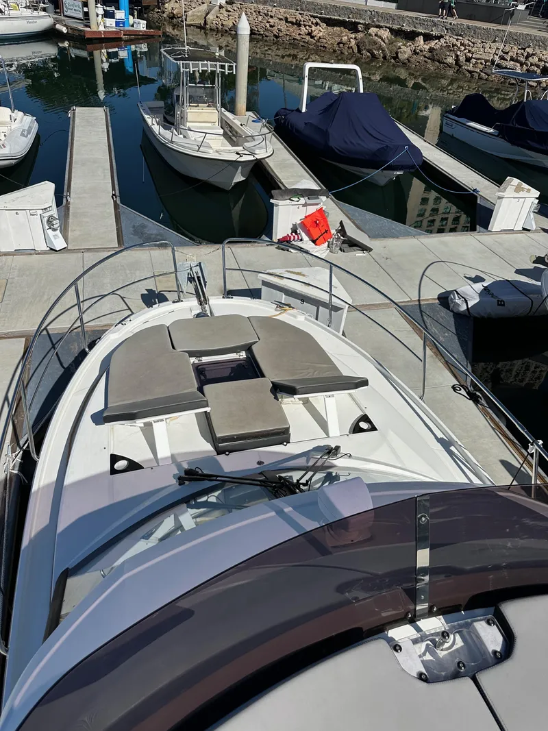 Slide: The Image of 2021 Jeanneau NC 1095 Fly yacht docked at marina, featuring spacious deck and seating. - 21