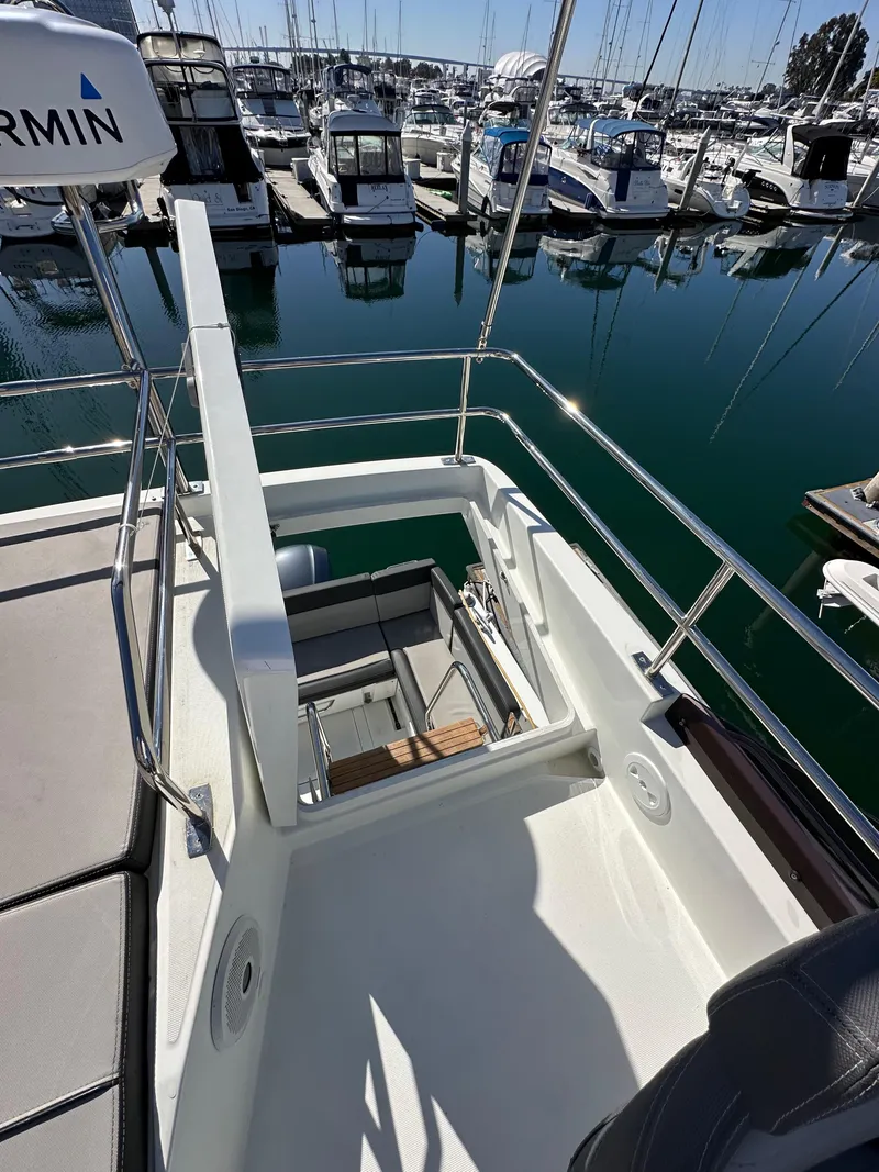 Slide: The Image of 2021 Jeanneau NC 1095 Fly yacht at marina, showcasing flybridge and sleek design. - 23