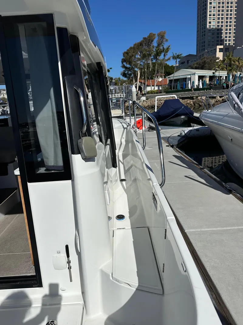 Slide: The Image of 2021 Jeanneau NC 1095 Fly yacht docked at marina, side view. - 26