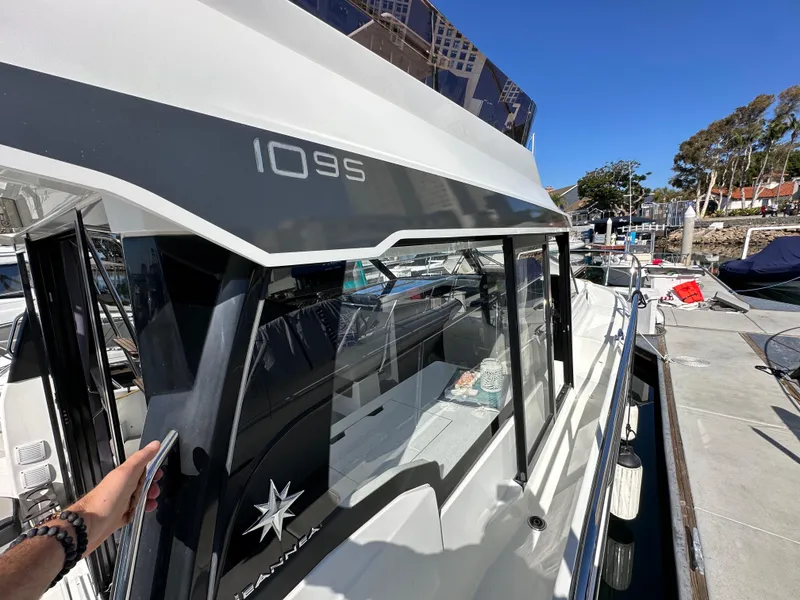 Slide: The Image of 2021 Jeanneau NC 1095 Fly yacht docked at marina, showcasing sleek design and modern features. - 27