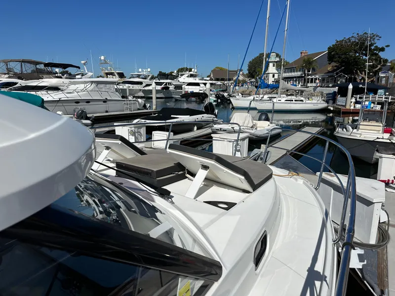 Slide: The Image of 2021 Jeanneau NC 1095 Fly yacht docked in a marina, surrounded by other boats. - 29