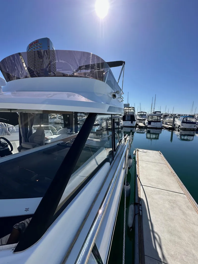 Slide: The Image of 2021 Jeanneau NC 1095 Fly yacht docked at marina under clear blue sky. - 34