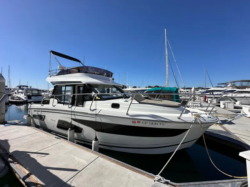 Slide: The Image of 2021 Jeanneau NC 1095 Fly yacht docked at marina under clear blue sky. - 4