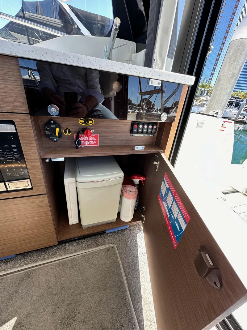 Slide: The Image of Interior view of 2021 Jeanneau NC 1095 Fly boat, featuring storage cabinet and safety equipment. - 41