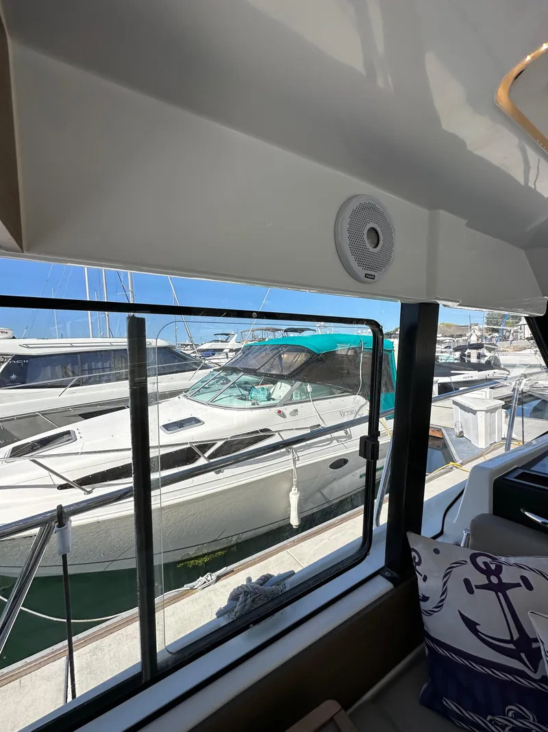 Slide: The Image of 2021 Jeanneau NC 1095 Fly interior view with marina backdrop. - 48